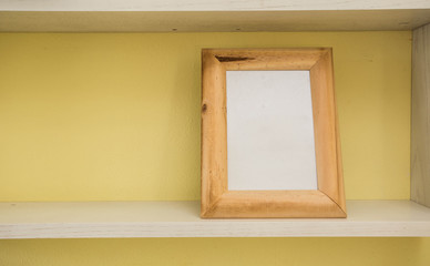 Empty blank vintage  picture frame with yellow wall