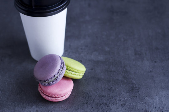 French macaroons with coffe at the dark background