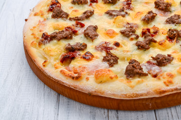 Minced meat tomato red onion pizza on a wood background. toning