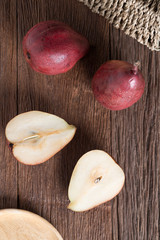 Half of Red pear and Red pear on wood table. Top view.