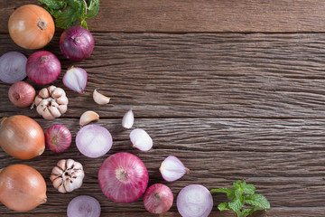Red onion and onion, garlic, mint on wood background. Top view.