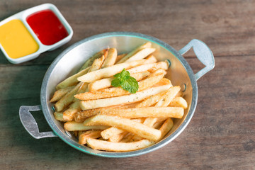 French fries on pan with tomato sauce and cheese sauce.