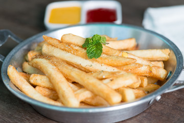 French fries on pan with tomato sauce and cheese sauce.