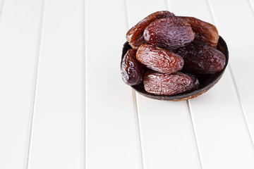 Isolated Organic Dates Medjul in coconut bowl on white background.