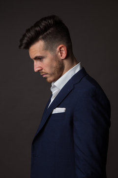 Side view of businessman standing against gray background