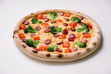 Pizza with smoked sausages and broccoli isolated on white