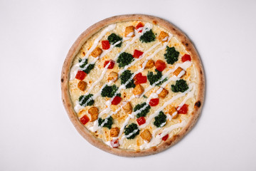 Pizza with chicken, tomato and spinach on white. Top view