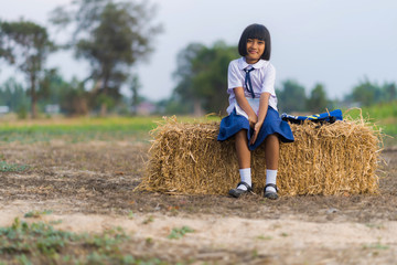 Naklejka na ściany i meble Asian student in uniform studying at countryside of Thailand