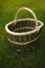 Wicker basket stands on a background of green grass.