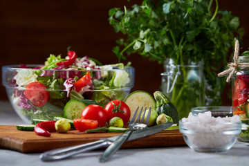 Fresh vegetable salad and ripe veggies on cutting board over white background, close up, selective focus