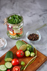 Fresh vegetable salad and ripe veggies on cutting board over white background, close up, selective focus