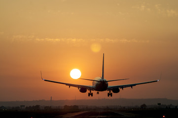 Airplane landing at Seville airport at sunset