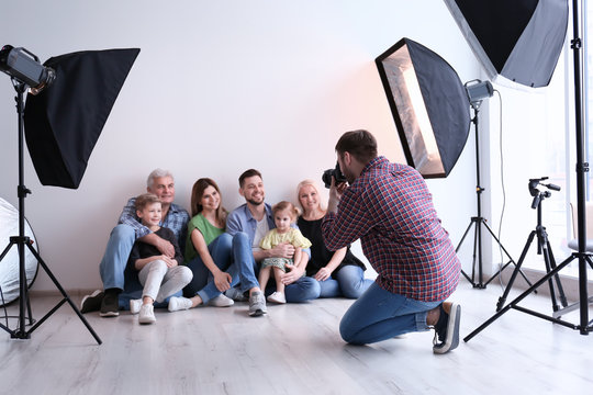 Professional photographer taking photo of family in studio