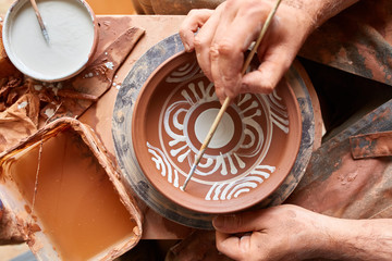 Scary face alike handmade potter mug on a wooden shelf, close-up, shellow depth of field.