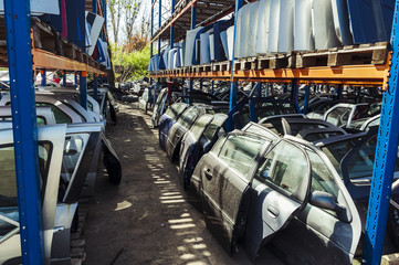 Layered rows of car doors/Car doors and windows sitting in layered rows in a recycling center after being disassembled.  - 201860906