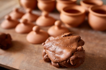 Making pottery on a potter's wheel in the workshop, close-up, selective focus.