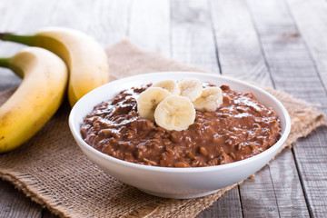 Raw oatmeal porridge with banana and chocolate