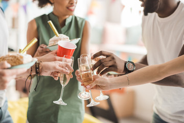 Young men and women toasting with champagne at birthday party