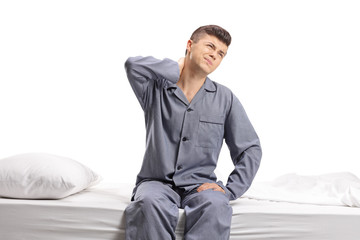 Teenager seated on a bed experiencing neck pain