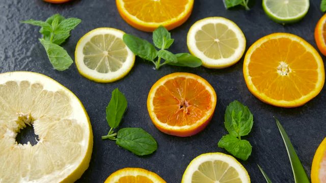 food, healthy eating and vegetarian concept - close up of grapefruit, orange, pomelo and lime slices on stone table