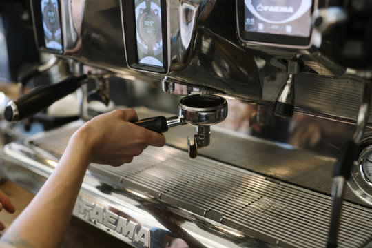 Barista's Hand Preparing Fresh Espresso Coffee on a Professional Machine