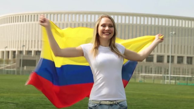 Woman with the flag of Colombia. Female soccer fan with Columbian flag.