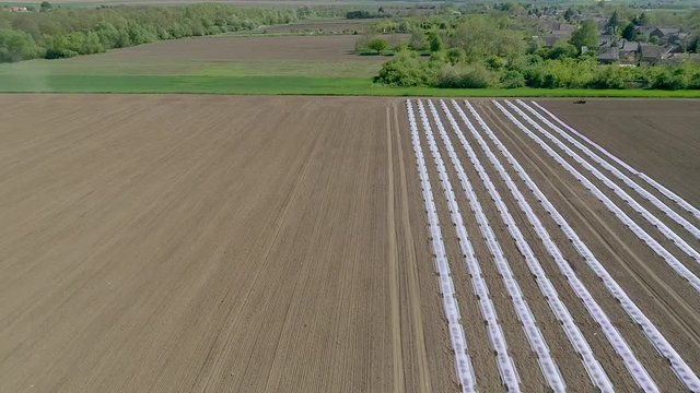 Aerial flight of field with tractor, slow motion video