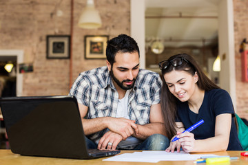 Couple of freelancers working with laptop in modern stylish coworking office, teamwork success concept