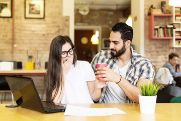 Couple of freelancers working with laptop in modern stylish coworking office, coffee time, teamwork success concept