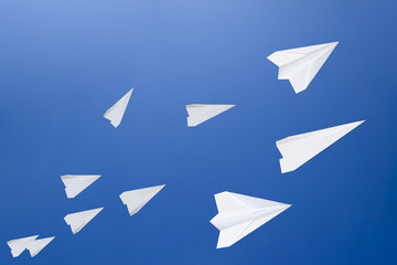 White paper airplanes against the blue sky. The symbol of freedom and privacy on the Internet.