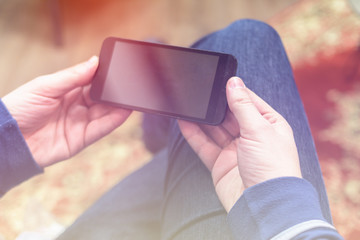 Closeup photo of man hold and watching video on smartphone, horizontal orientation.