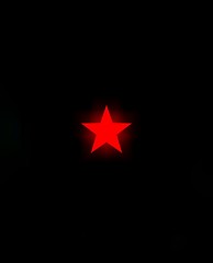 Obraz premium Red glowing neon star icon on a black background. 