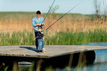 Father with son fishing on a pier