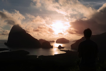 Man silhouette stay on mountain, sea and mountain with sunrise background. Satisfy hiker enjoy view.