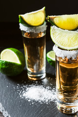 three glasses of tequila and pieces of lime
