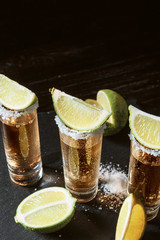 three glasses of tequila and pieces of lime