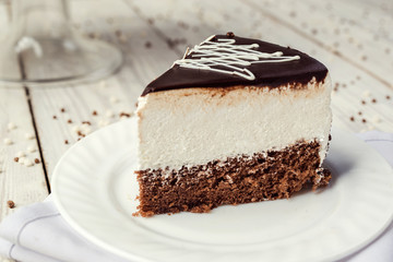 dark chocolate vegan cake with cream on wooden background