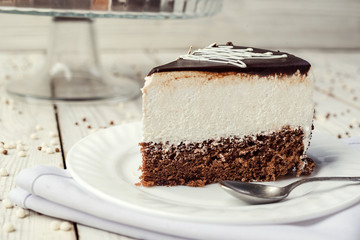 dark chocolate vegan cake with cream on wooden background