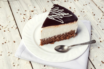 dark chocolate vegan cake with cream on wooden background