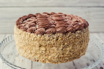 dark chocolate vegan cake with cream and caramel on wooden background