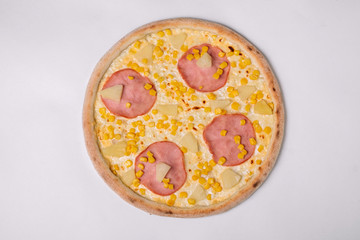 Pizza with ham, pineapple and corn isolated on white. Top view