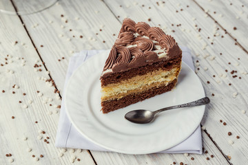 dark chocolate vegan cake with cream and caramel on wooden background