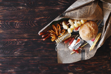 a can of beer with a snack on a wooden dark background . gift bouquet to a man. men's holiday gift
