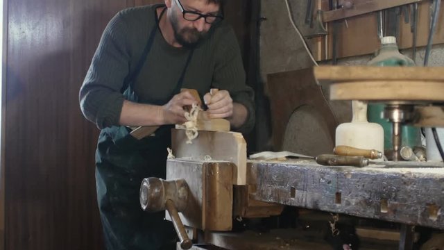 carpenter planes by hand a wooden board