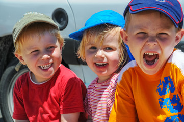 Drei fröhliche Kinder haben Spaß auf einem Sommerfest und spaßen und lachen zusammen 