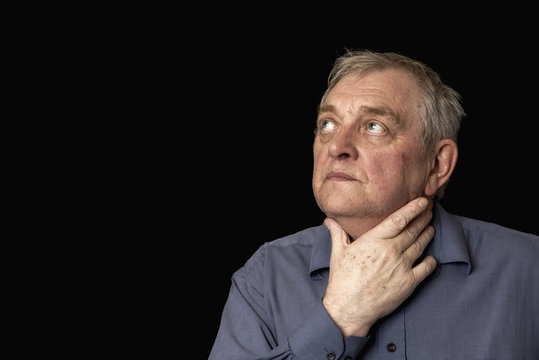 Portrait image of a mature Caucasian man looking upset and worried, on a black background