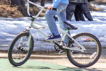 boy in blue jeans on a white bicycle