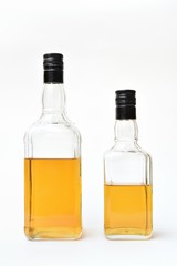 Transparent bottles with alcohol, started. Semi-empty bottles with alcohol on a white background