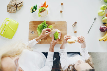 Top view mother daughter preparing school snack lunch home kitchen