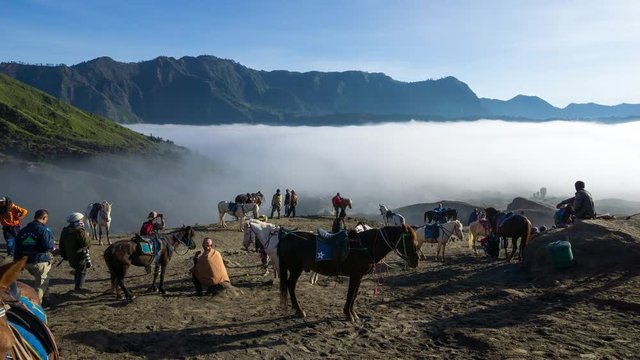 4K Time lapse of Bromo horsemen and foggy morning over mountain range at Mount Bromo, Semeru, Tengger National Park, Indonesia.